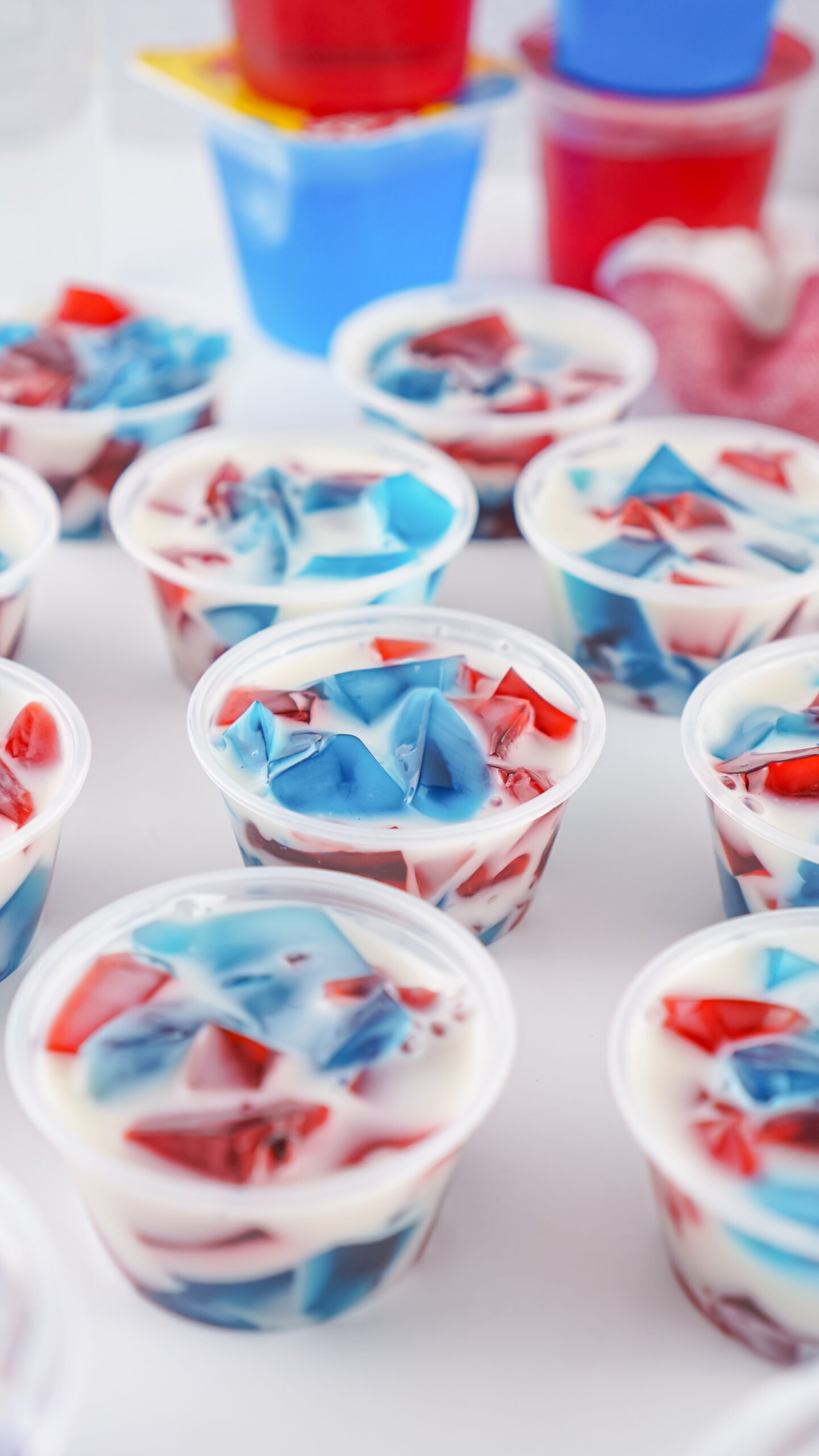 red, white, and blue jello shots on a white table 