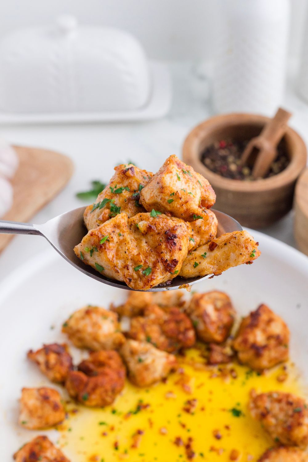 spoon with pieces of garlic butter chicken bites on it