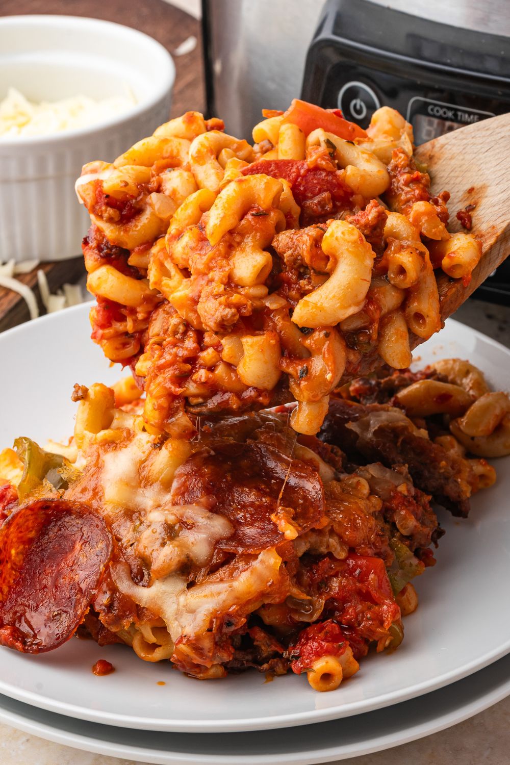 Slow Cooker Pizza Casserole being put on a plate on table 