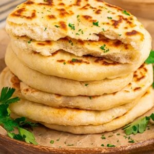3 Ingredient Flatbreadstacked on table with parsley sprinkled on top and some around platter