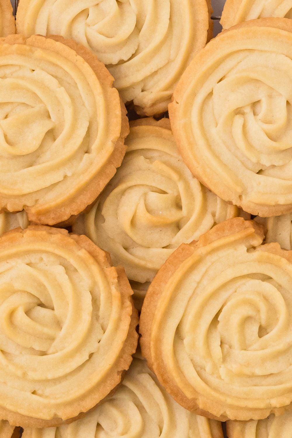 close up of Butter Cookies laid out on table that are stacked together 