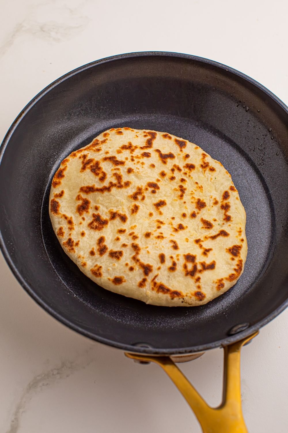 skillet with a 3 Ingredient Flatbread in it browning up 