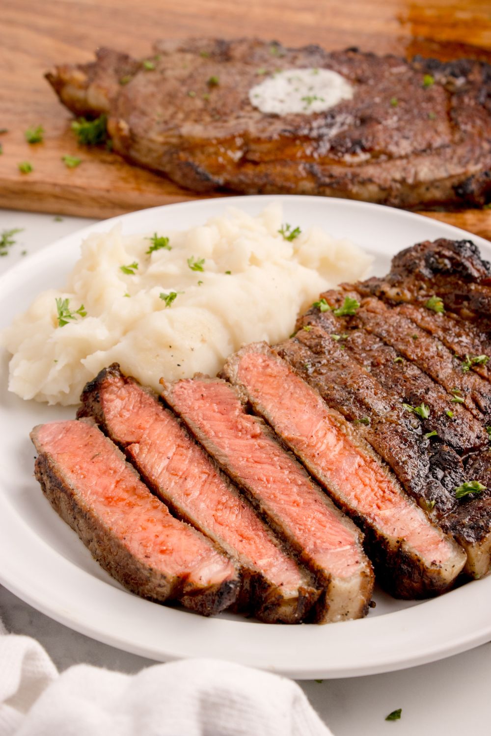 plate with mashed potatoes and sliced Grilled Ribeye Steak on plate 
