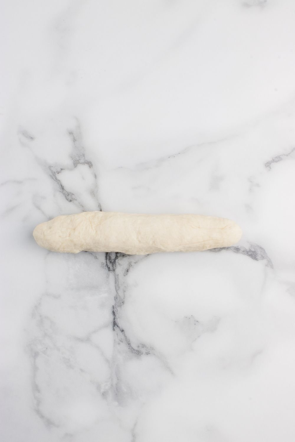 one dough ball rolled out into a snake 