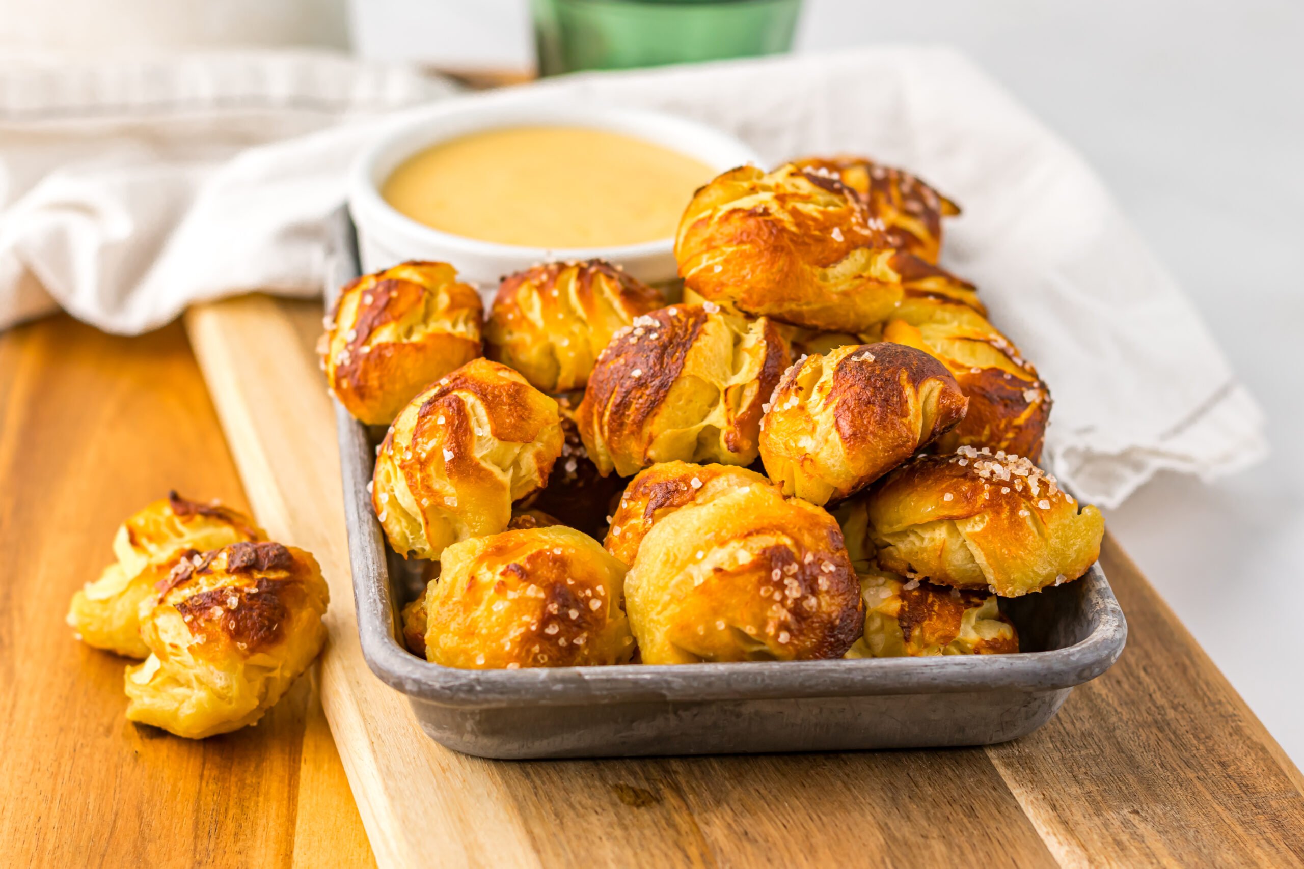 Easy Biscuit Pretzel Bites with Cheese Sauce on a tray sitting on a wooden table 