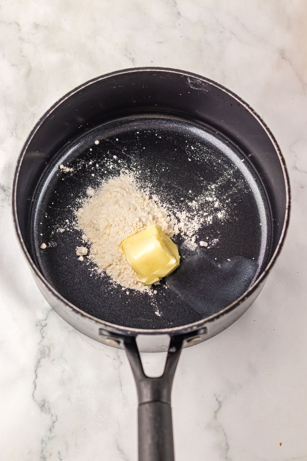 butter and flour in a saucepan on table 