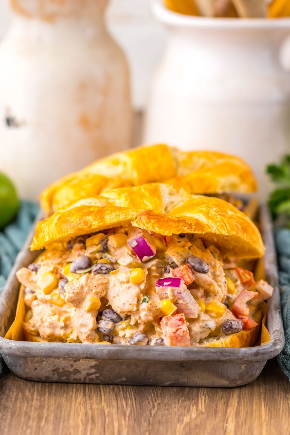 view of Creamy Taco Chicken Salad sandwiches on table with mason jar behind on table 