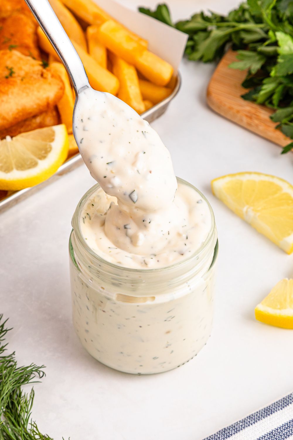 Easy Homemade Tarter Sauce in a jar with a spoon with some lifting out of jar 