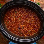 looking down to table with Crockpot Bourbon Brown Sugar Baked Beans in a Crockpot on table