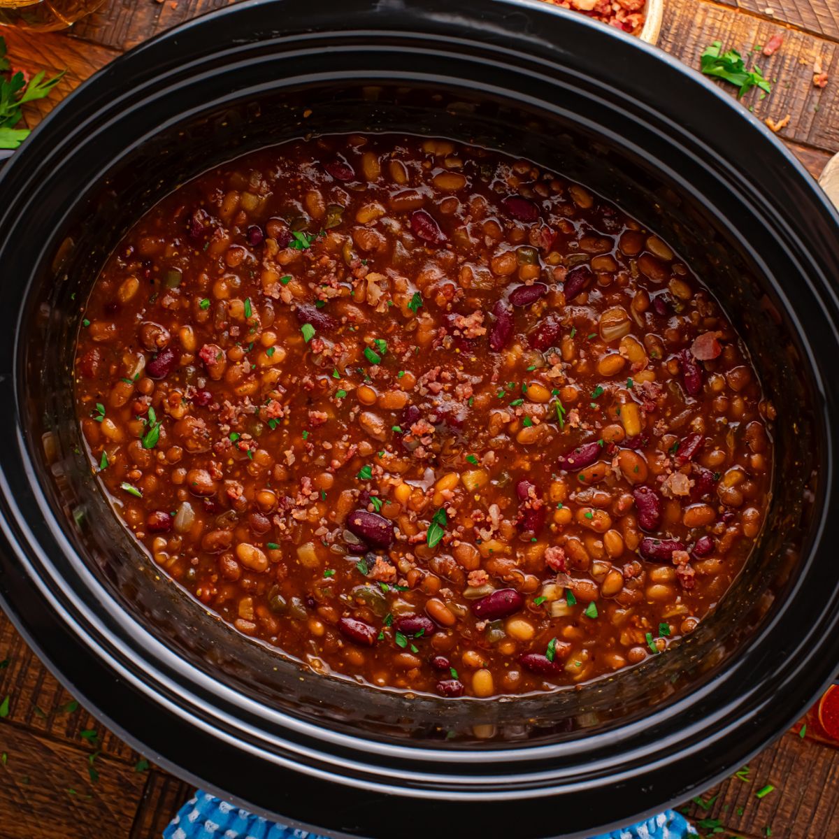 looking down to table with Crockpot Bourbon Brown Sugar Baked Beans in a Crockpot on table 