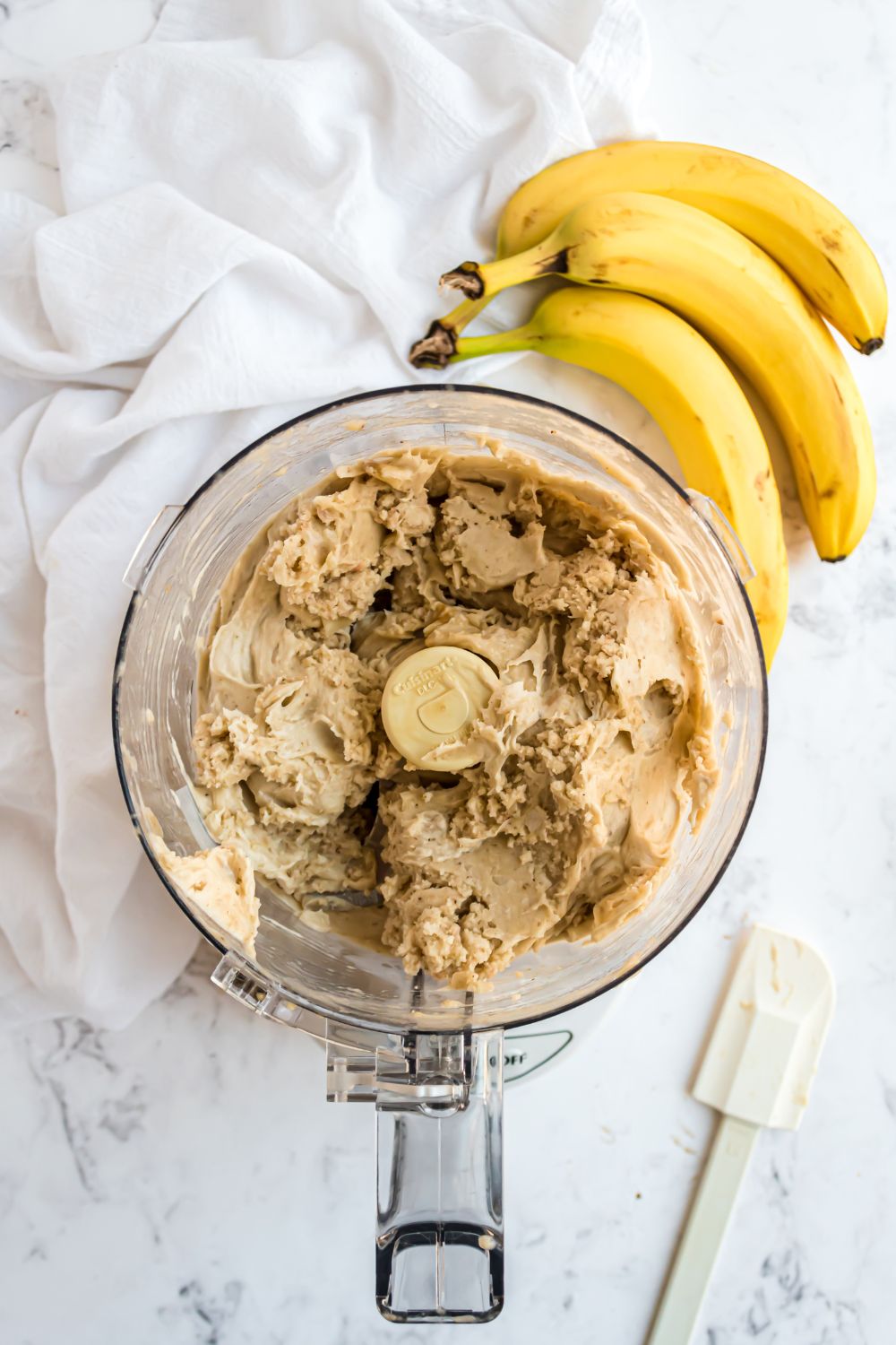 Banana Ice Cream being made in a food processor with bananas to side 