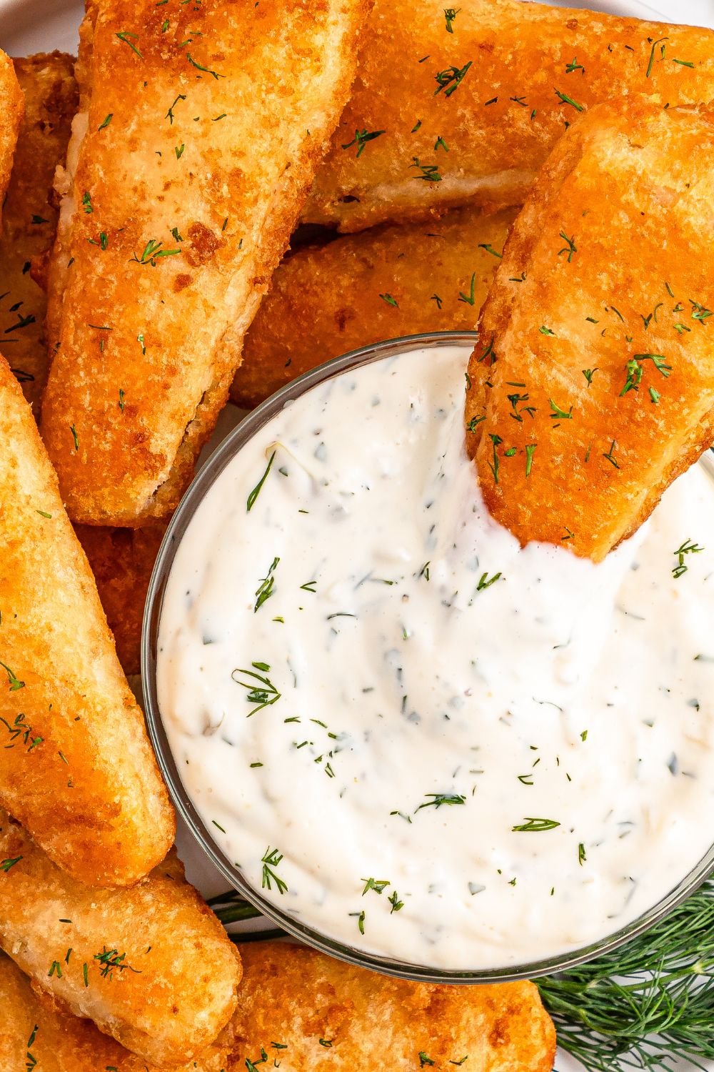 Easy Homemade Tarter Sauce in a bowl with a piece of fish dipping in the bowl 