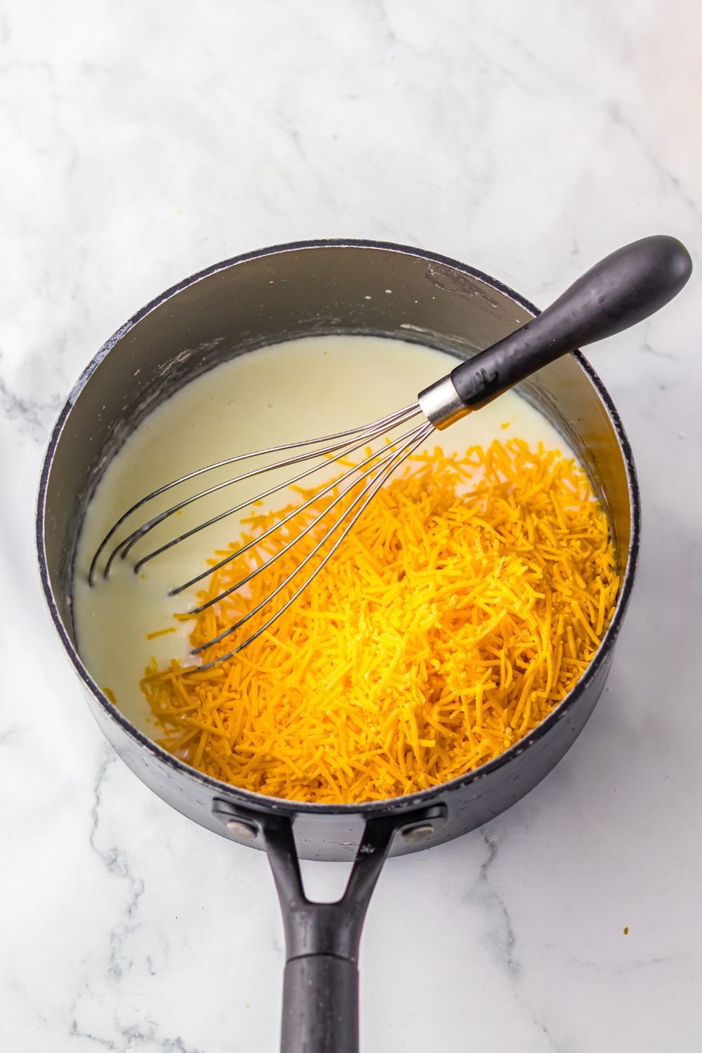 cheese and sauce in a saucepan sitting on table 