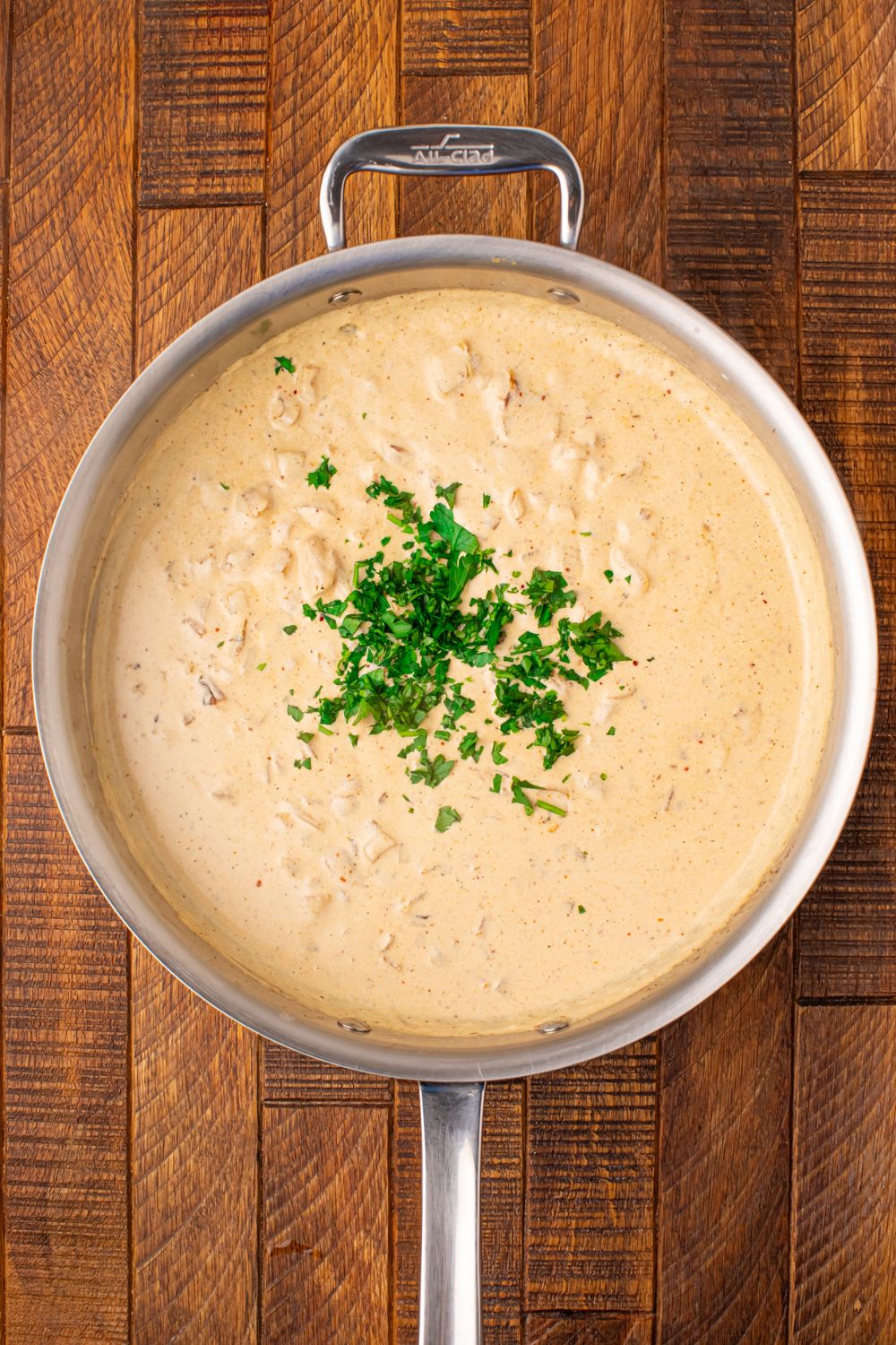 creamy garlic parmesan sauce with parsley on top of it 