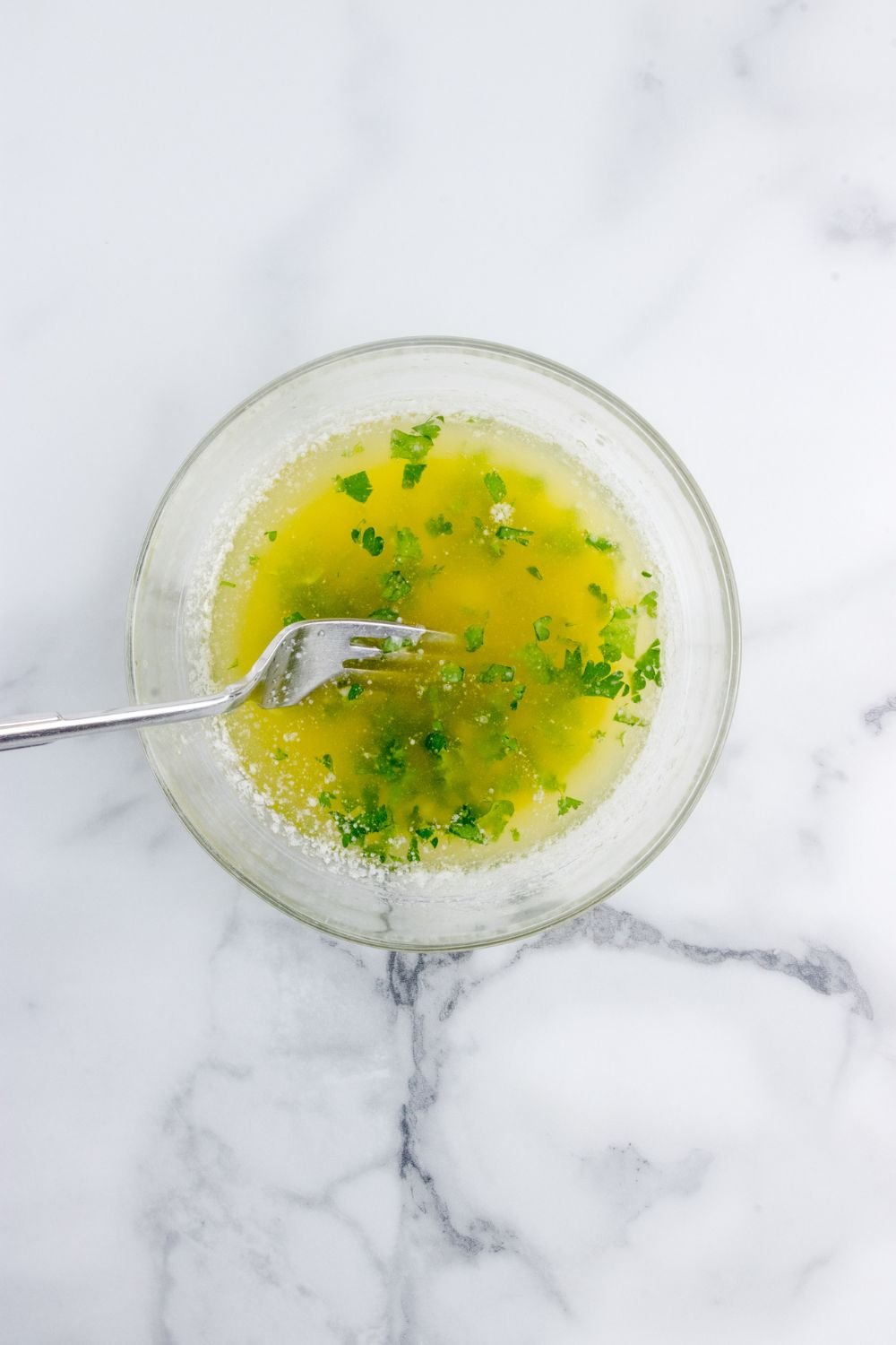 bowl of garlic butter sauce with fork in it 
