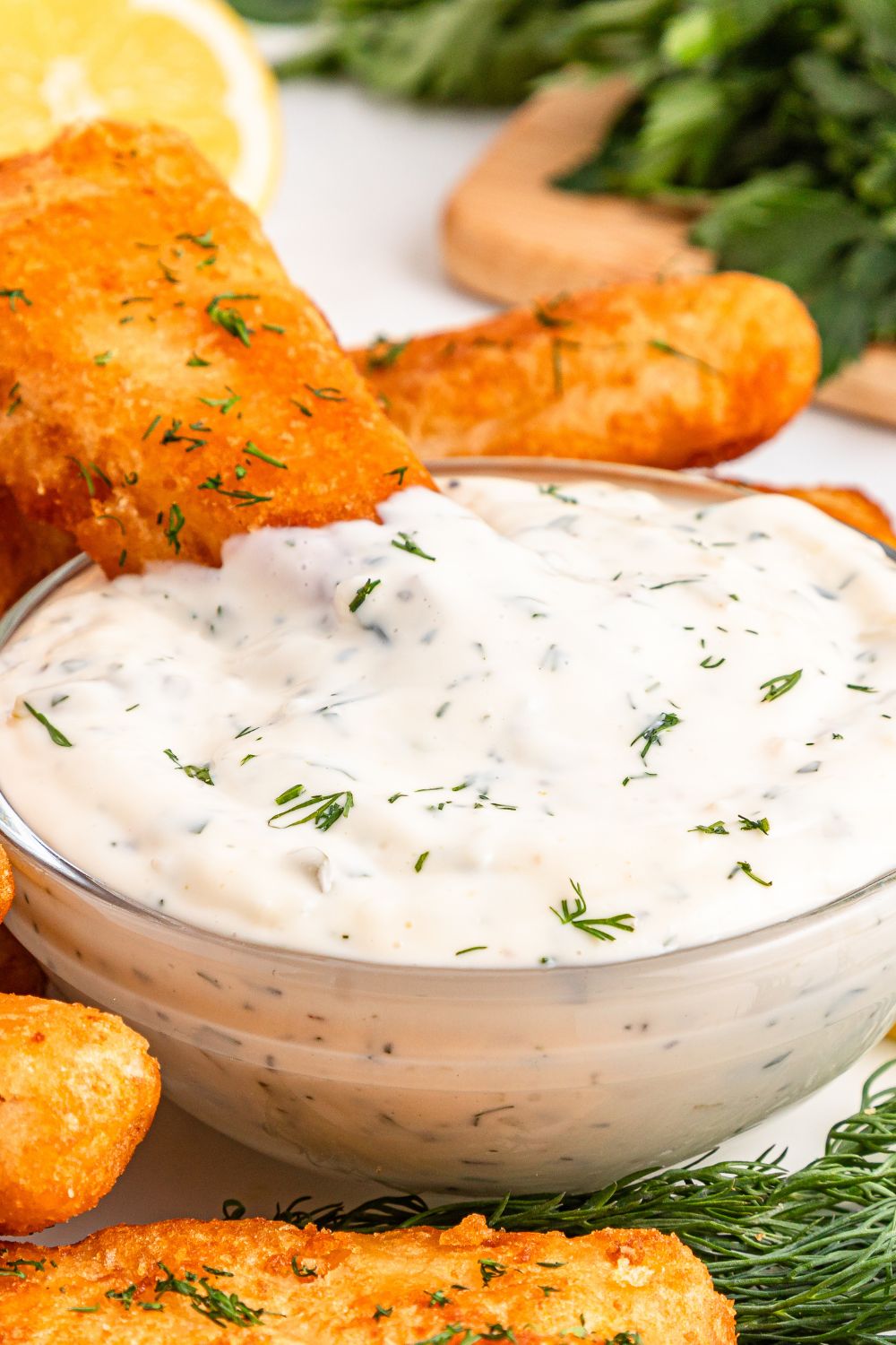 Easy Homemade Tarter Sauce in a bowl with a fish fillet stuck in the bowl 