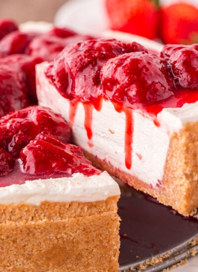 No Bake Strawberry Cheesecake on tray with a slice taken out to see how decadent the cheesecake is