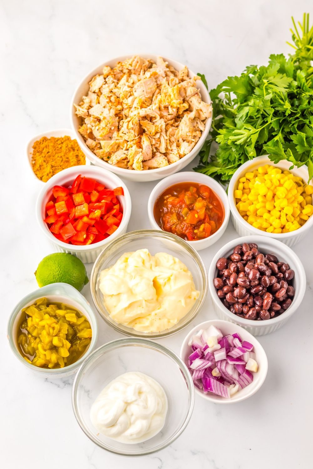 ingredients for Creamy Taco Chicken Salad  in single serve bowls sitting on table 