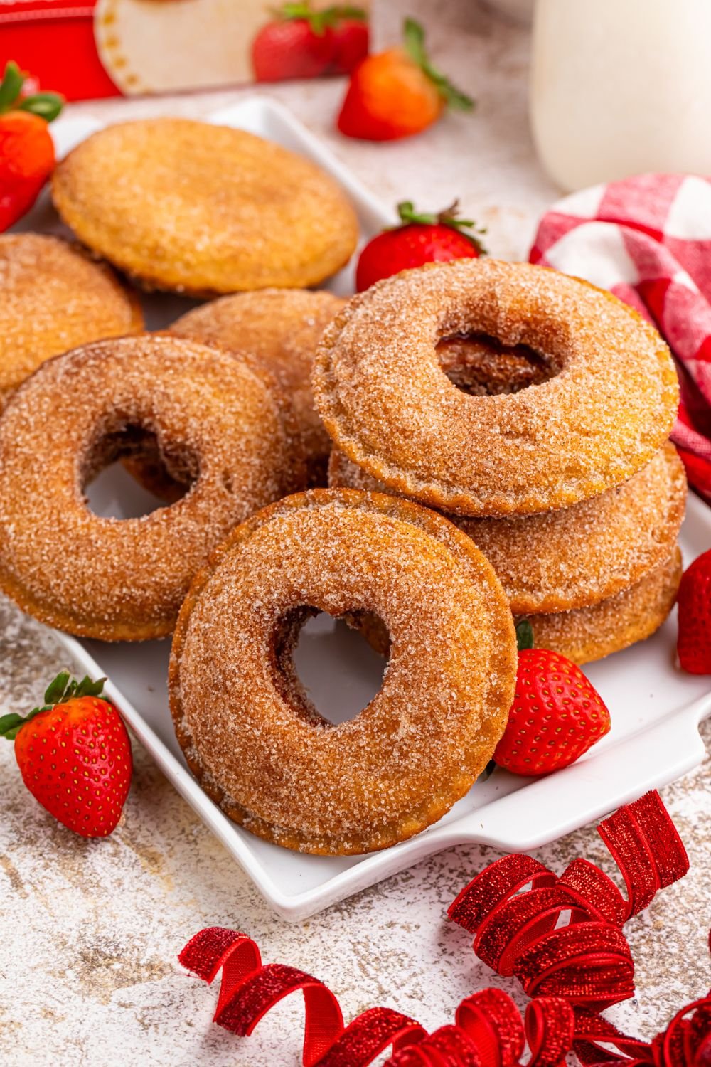 Fried Strawberry Uncrustables on table with ribbon and strawberries scattered around on table 