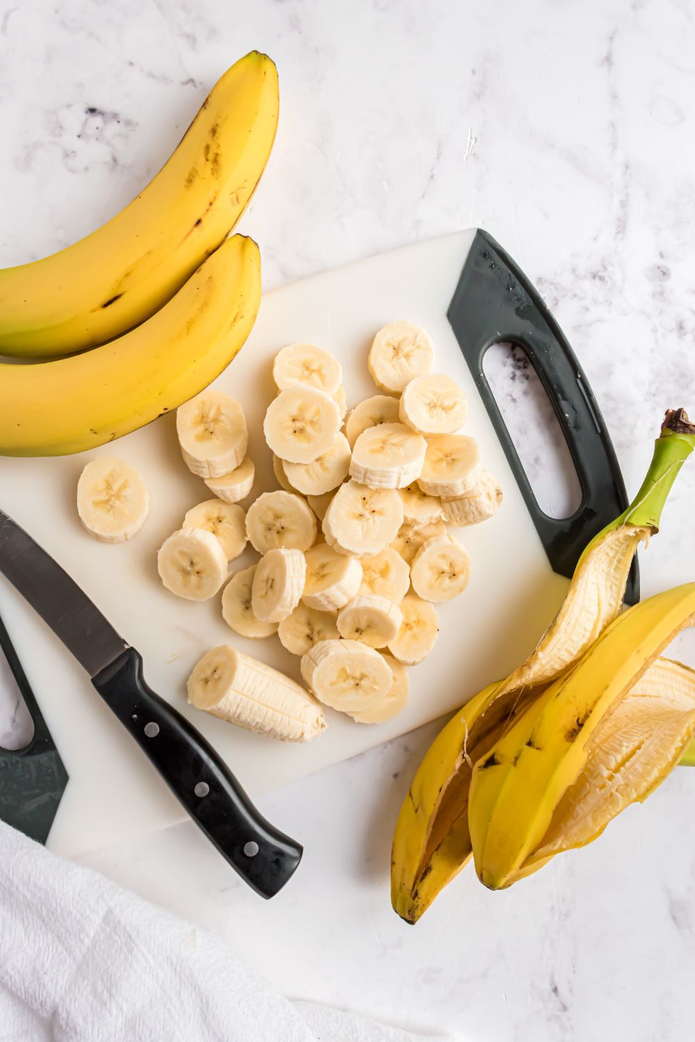 bananas sliced and placed on a cutting board with peels to side for making Banana Ice Cream