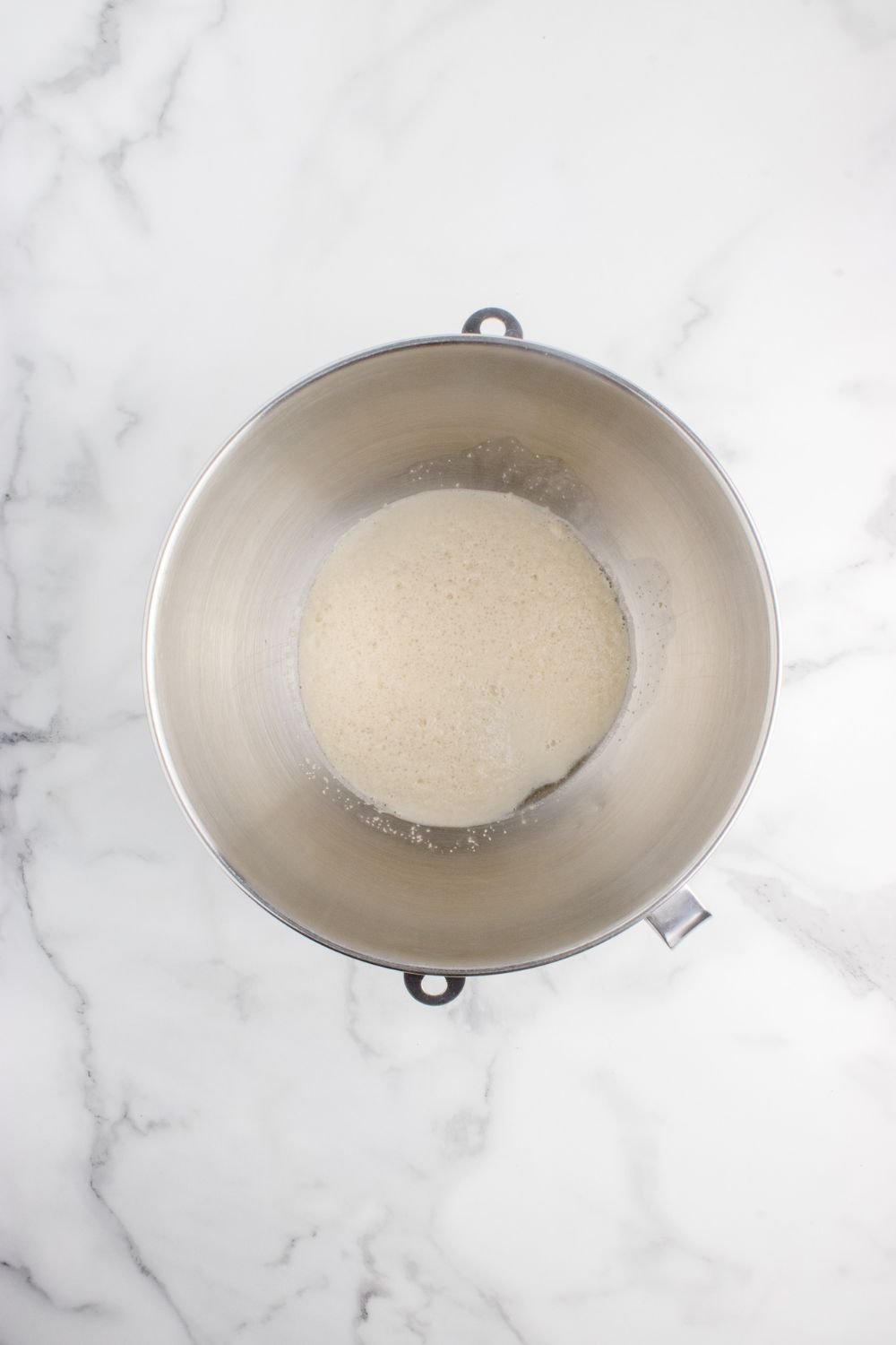yeast mixture in a metal bowl on table 