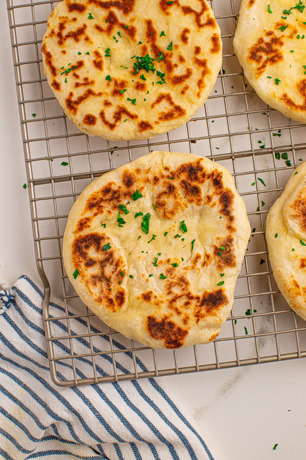3 Ingredient Flatbreads on cooling rack with a towel under cooling rack 