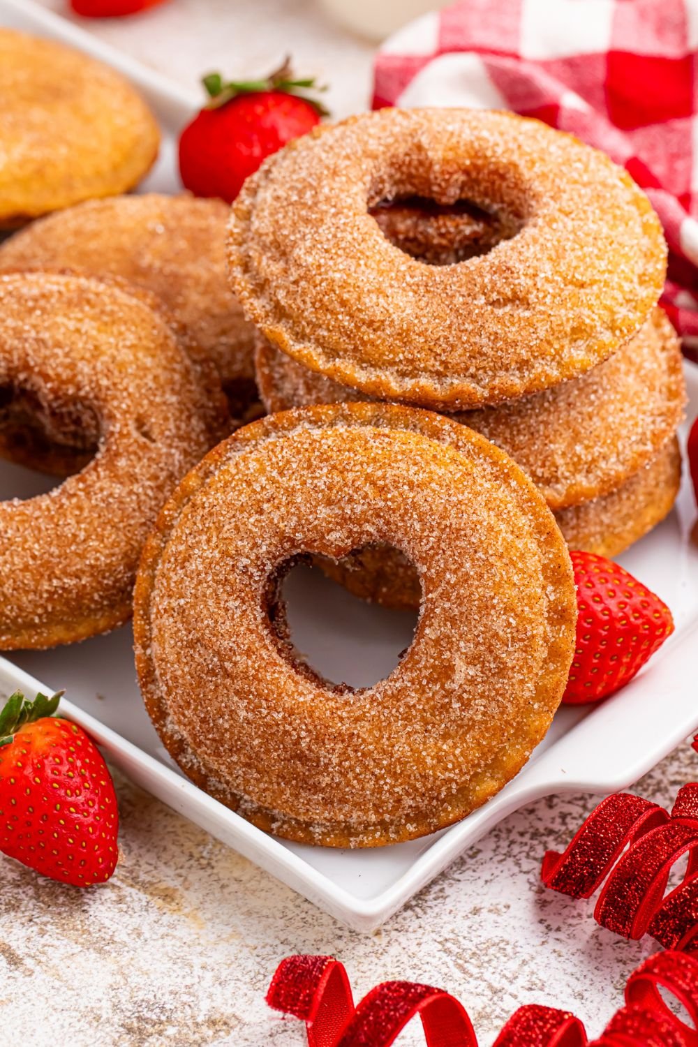 Uncrustables on a plate with hearts cut out and strawberries around table 