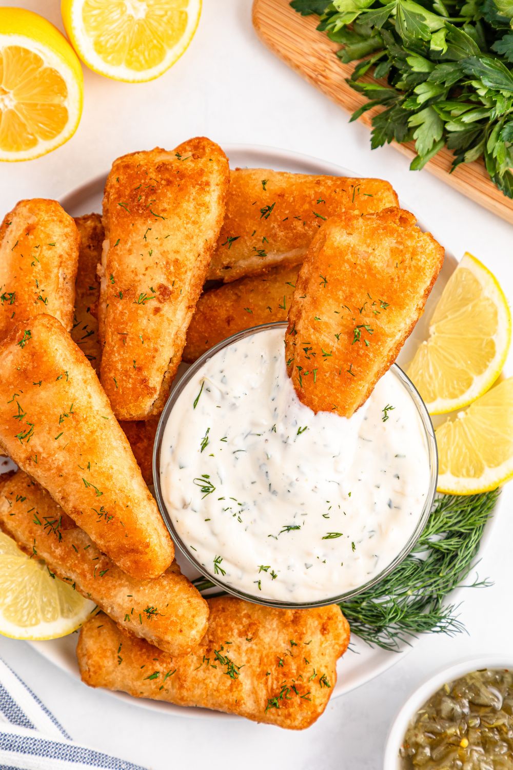 Easy Homemade Tarter Sauce dipped in a sauce with fish all around the tray