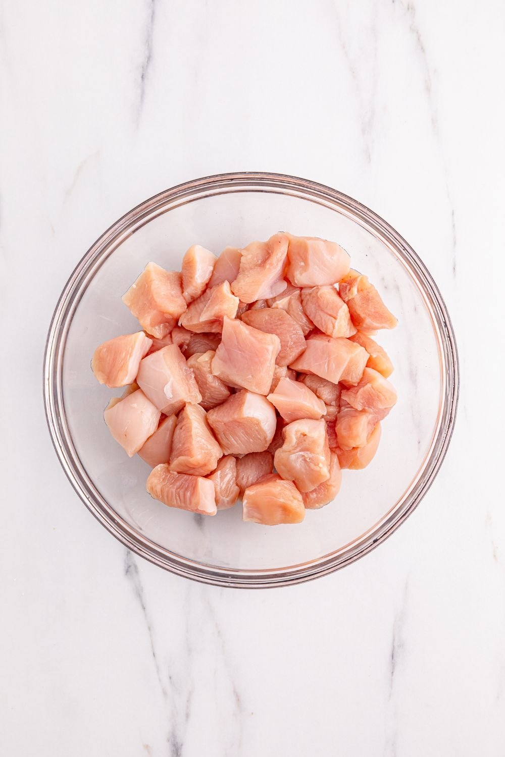 raw chicken cubed up in a bowl for making Better Than Takeout Kung Pao Chicken
