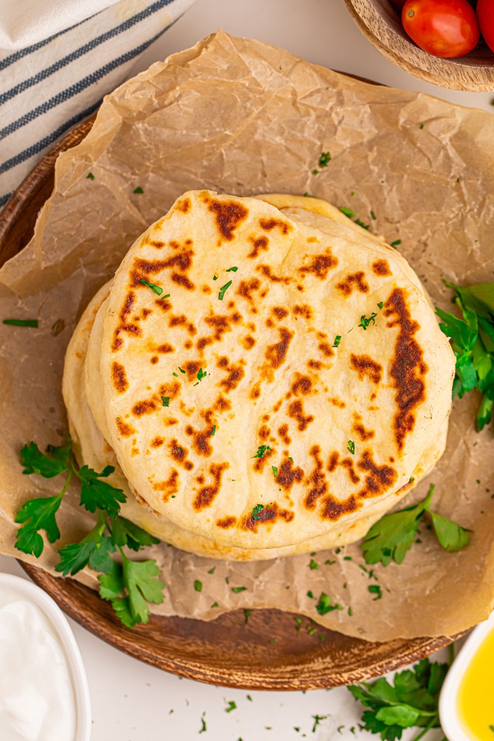 overhead look at table with a stack of 3 Ingredient Flatbread on it with parchment paper crinkled on table