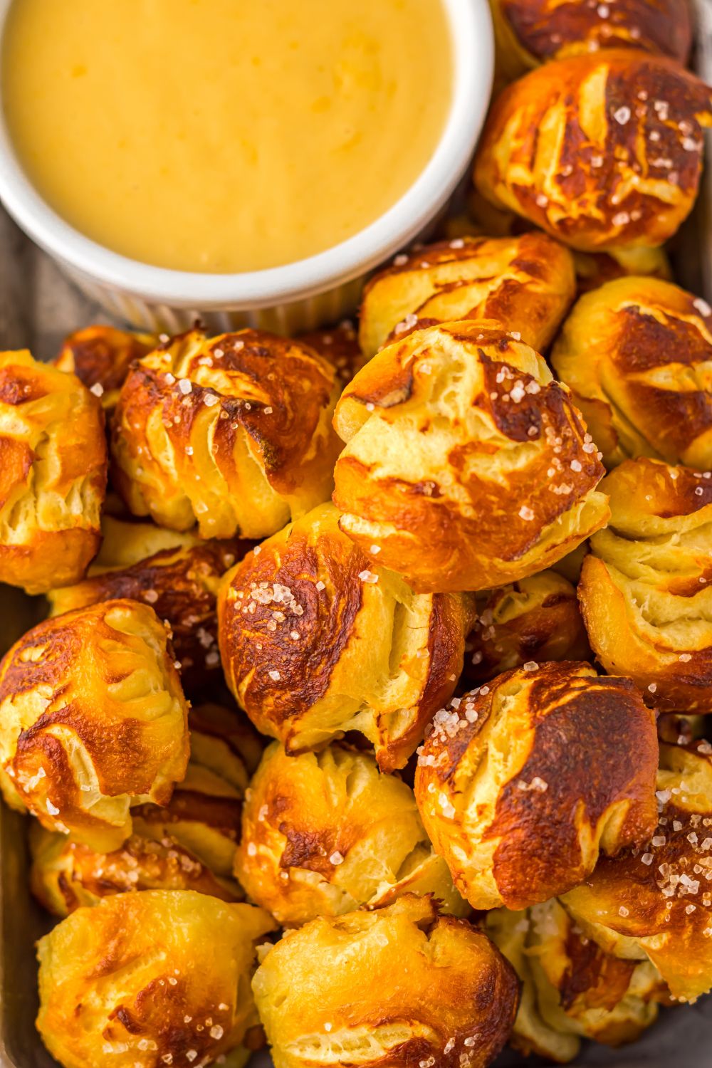 close up of Easy Biscuit Pretzel Bites with Cheese Sauce in a bowl to side 