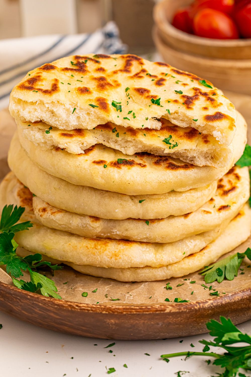 3 Ingredient Flatbread stacked on table with one cut in half to show fluffy texture 
