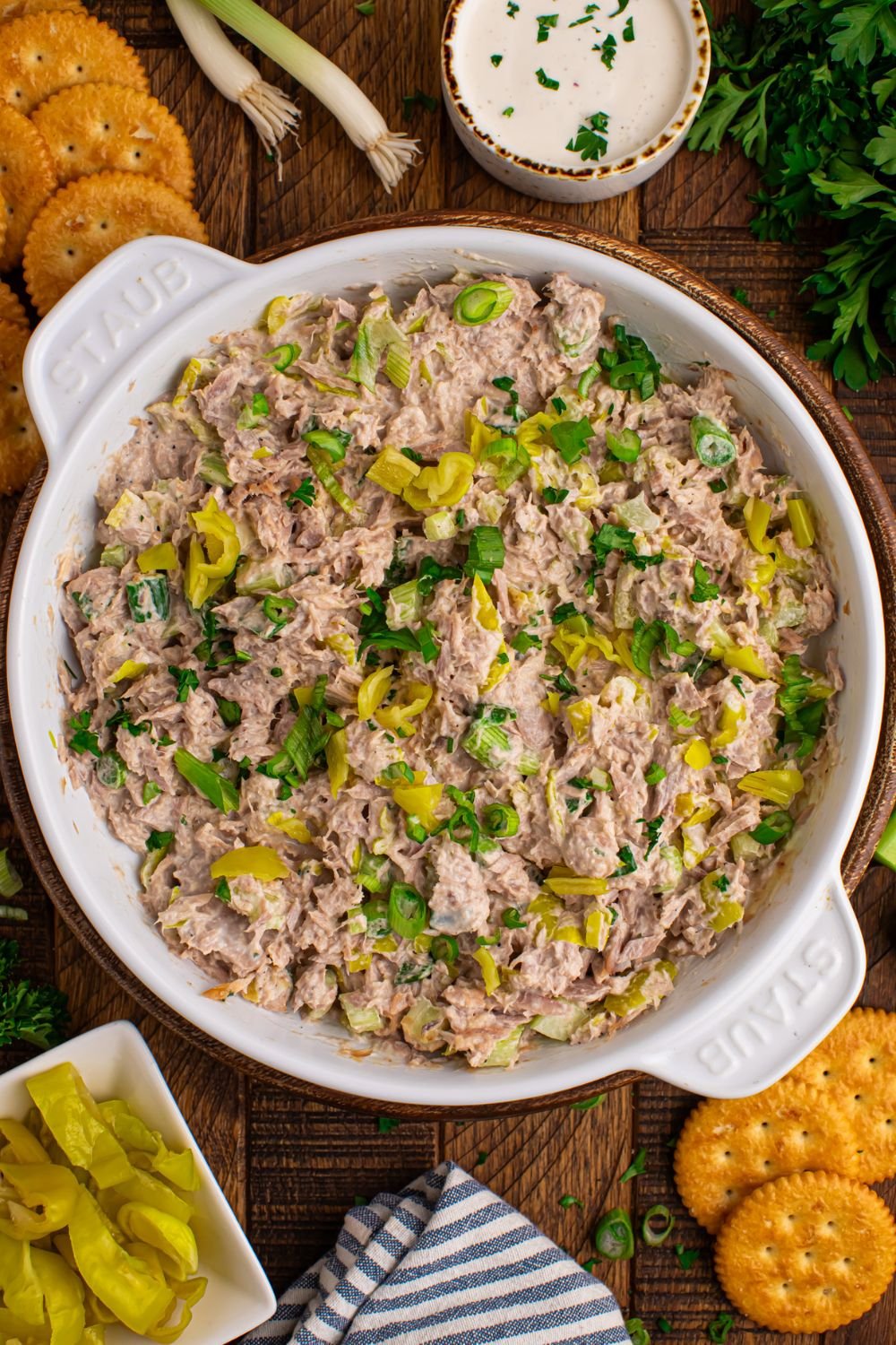 overhead look of white bowl on table with Pepperoncini Ranch Tuna Salad and crackers and peppers beside the bowl 
