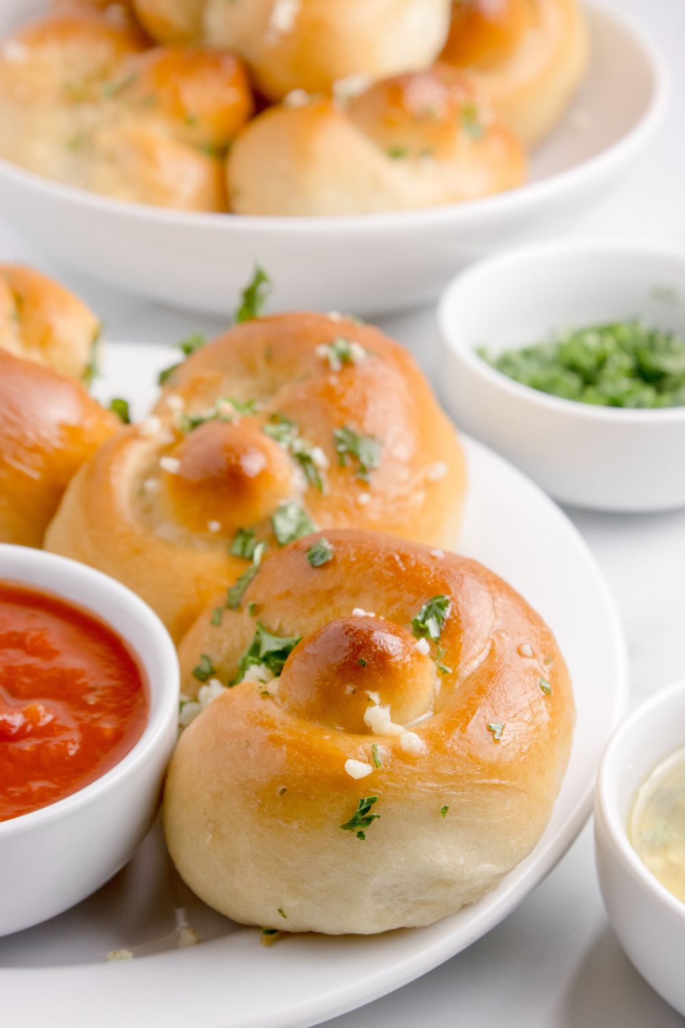 plate with Homemade Garlic Knots with a bowl of sauce to side 