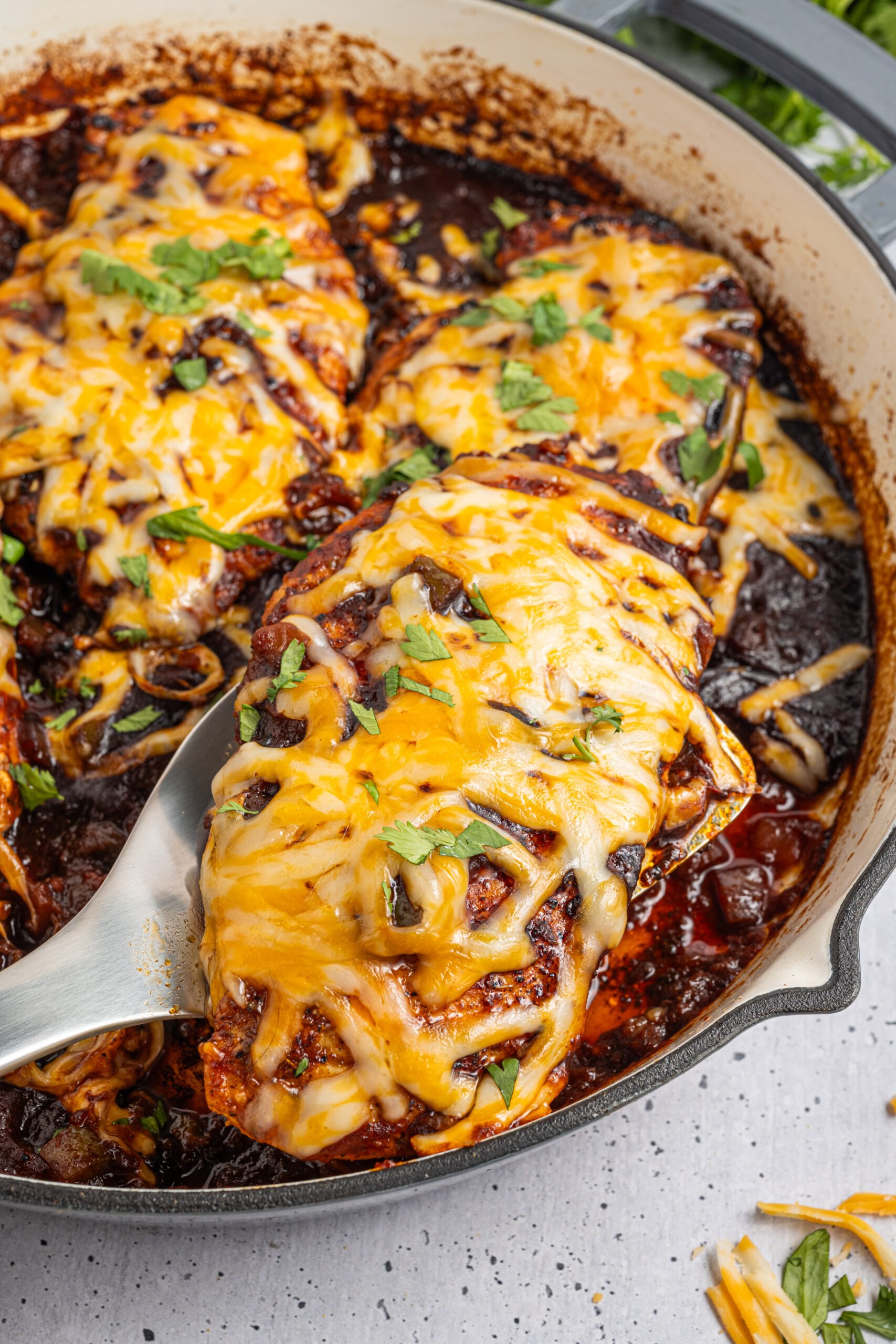 Cheesy Salsa Chicken in a skillet up close covered in cheese