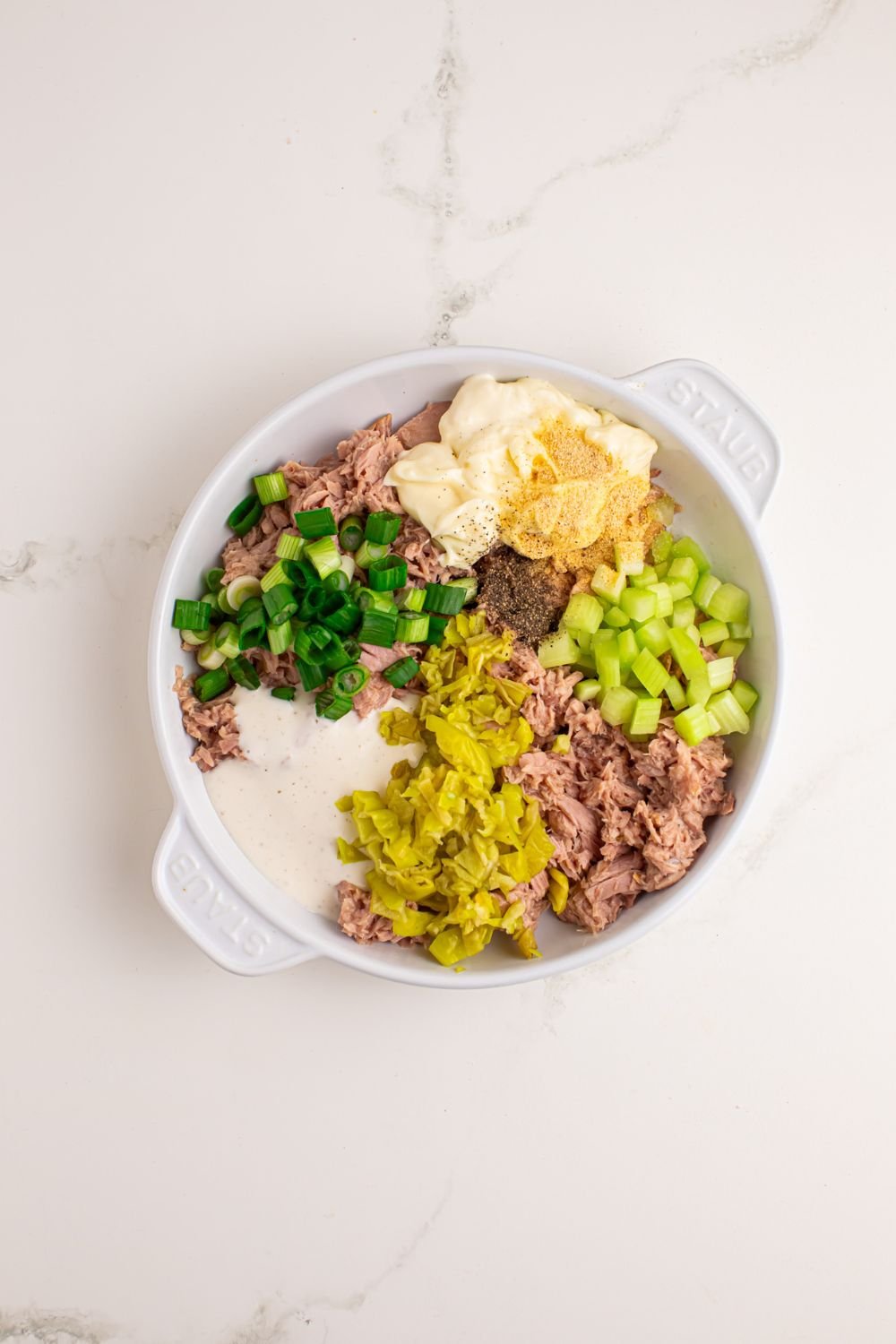 Pepperoncini Ranch Tuna Salad added into a bowl on table