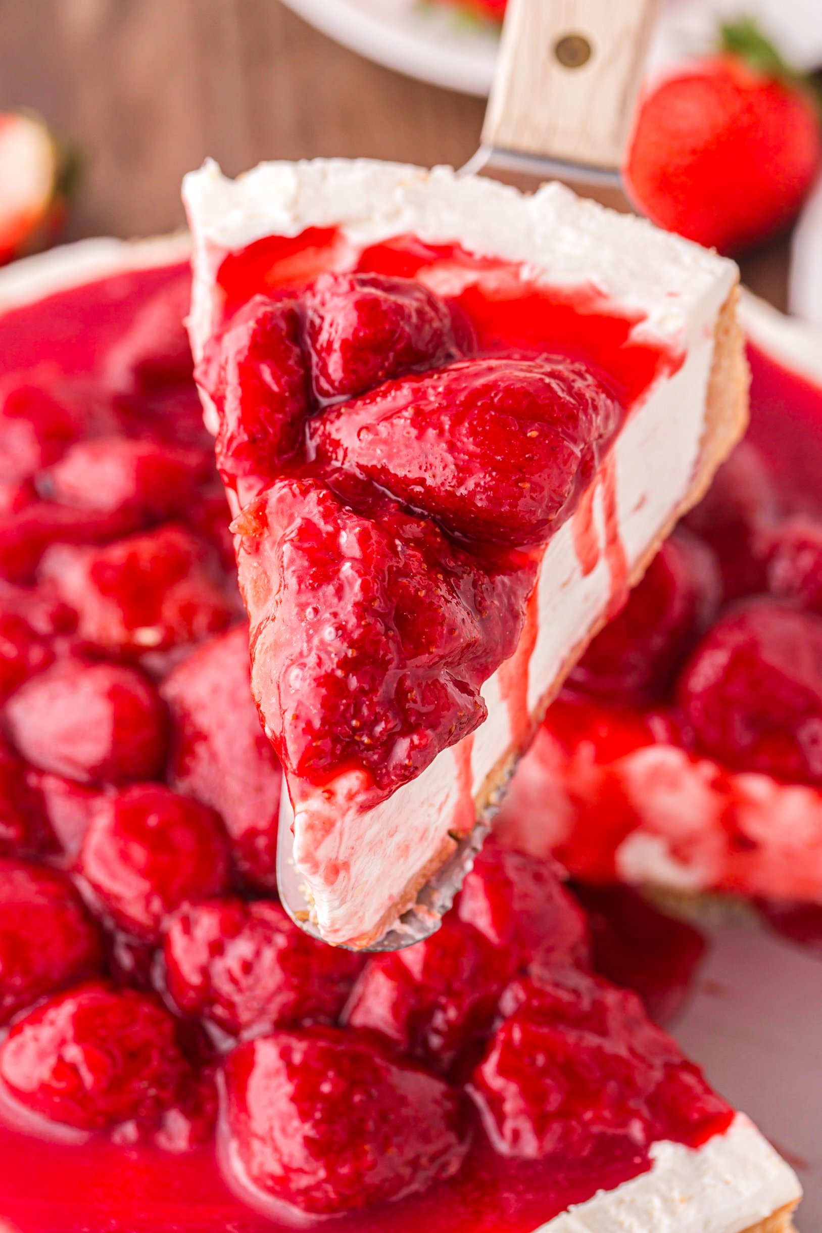 slice of No Bake Strawberry Cheesecake being lifted up 