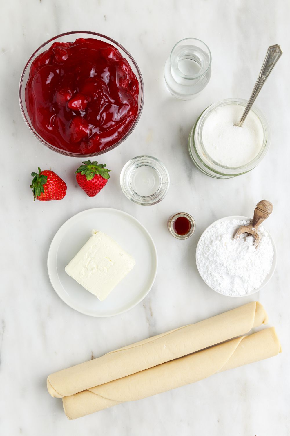 Deep Fried Strawberry Cheesecake Pies ingredients on table in single serve containers 
