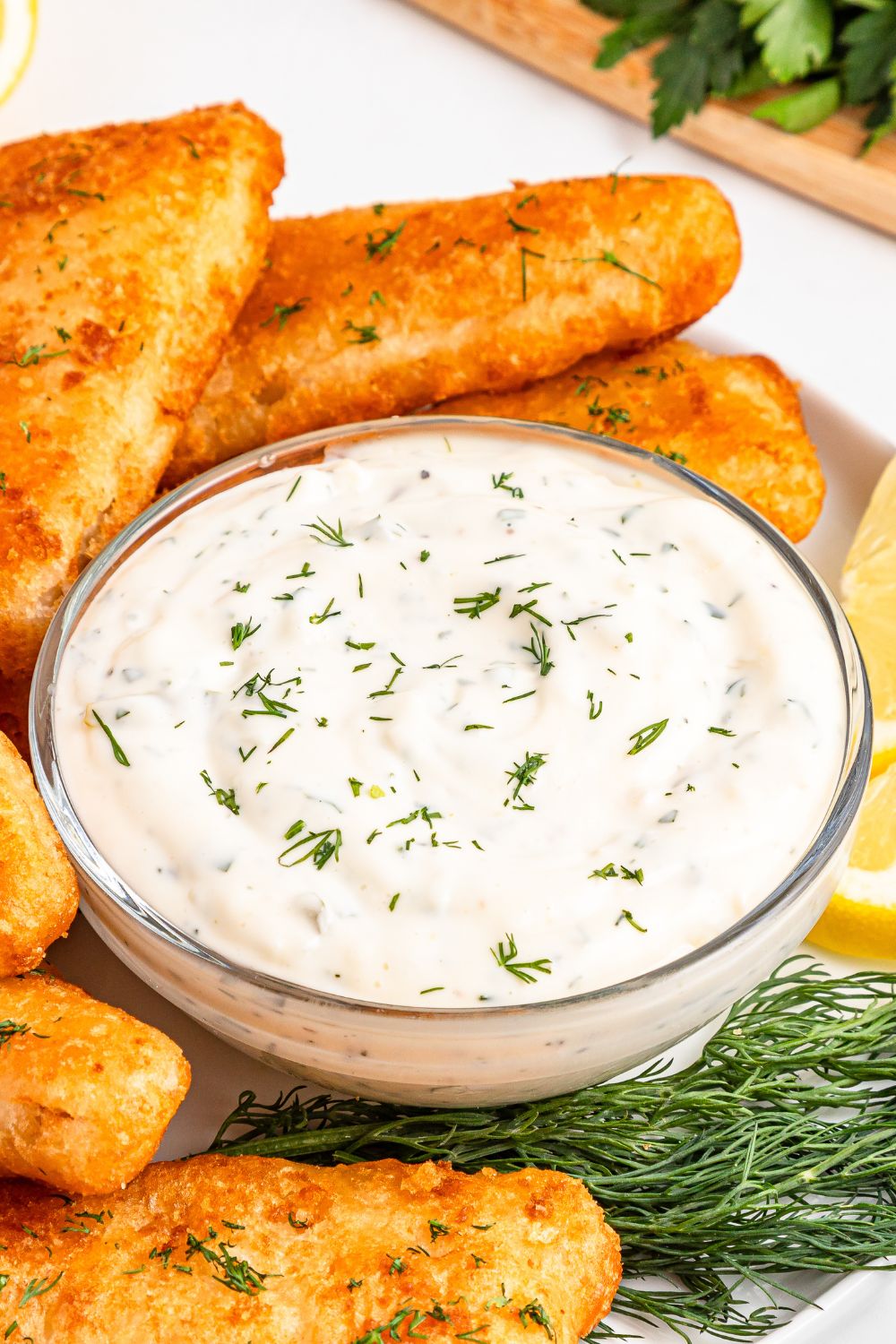 Easy Homemade Tarter Sauce in a bowl with fish to the side of it 