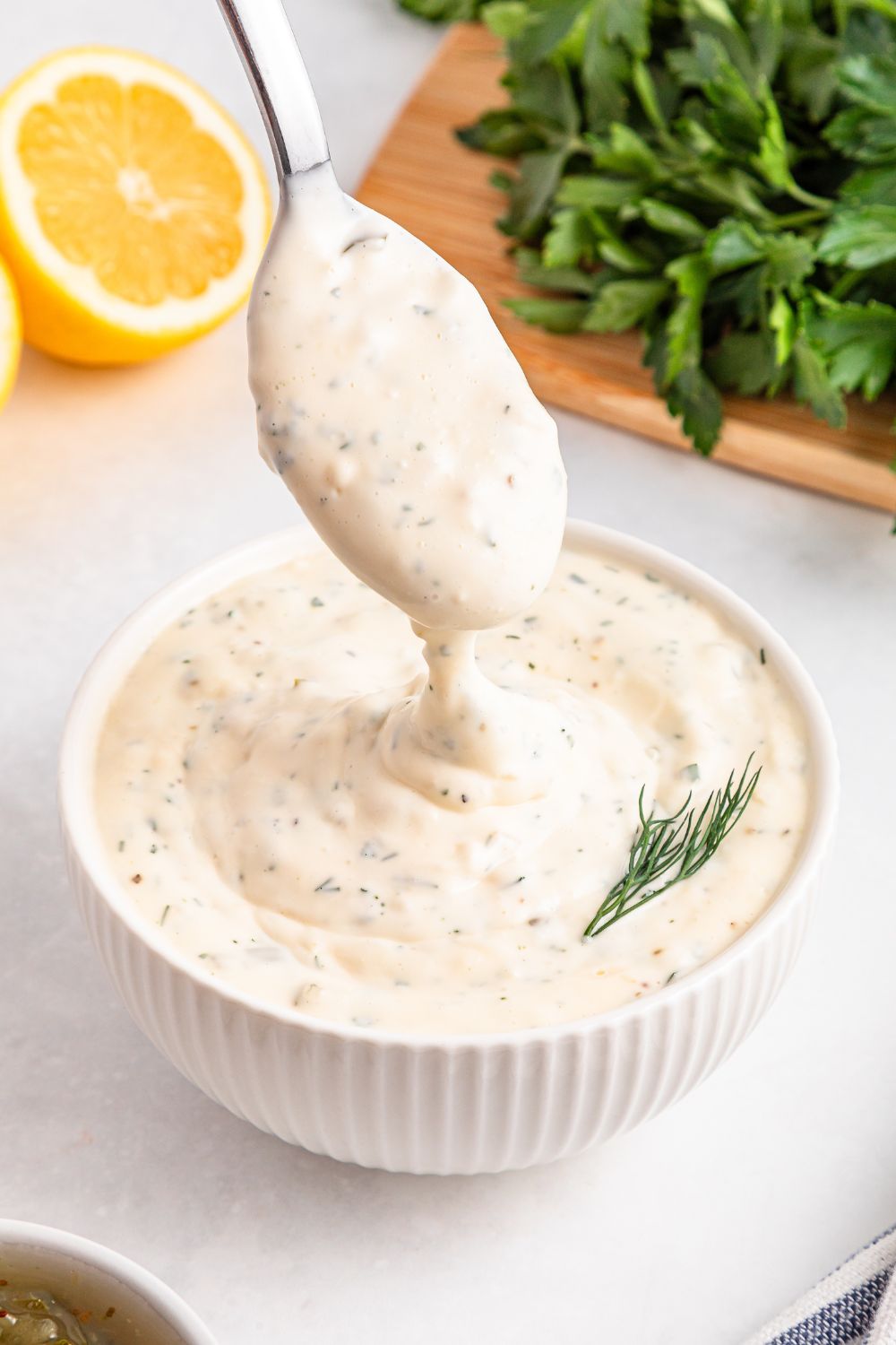 Easy Homemade Tarter Sauce in a bowl with a spoon lifting some up 