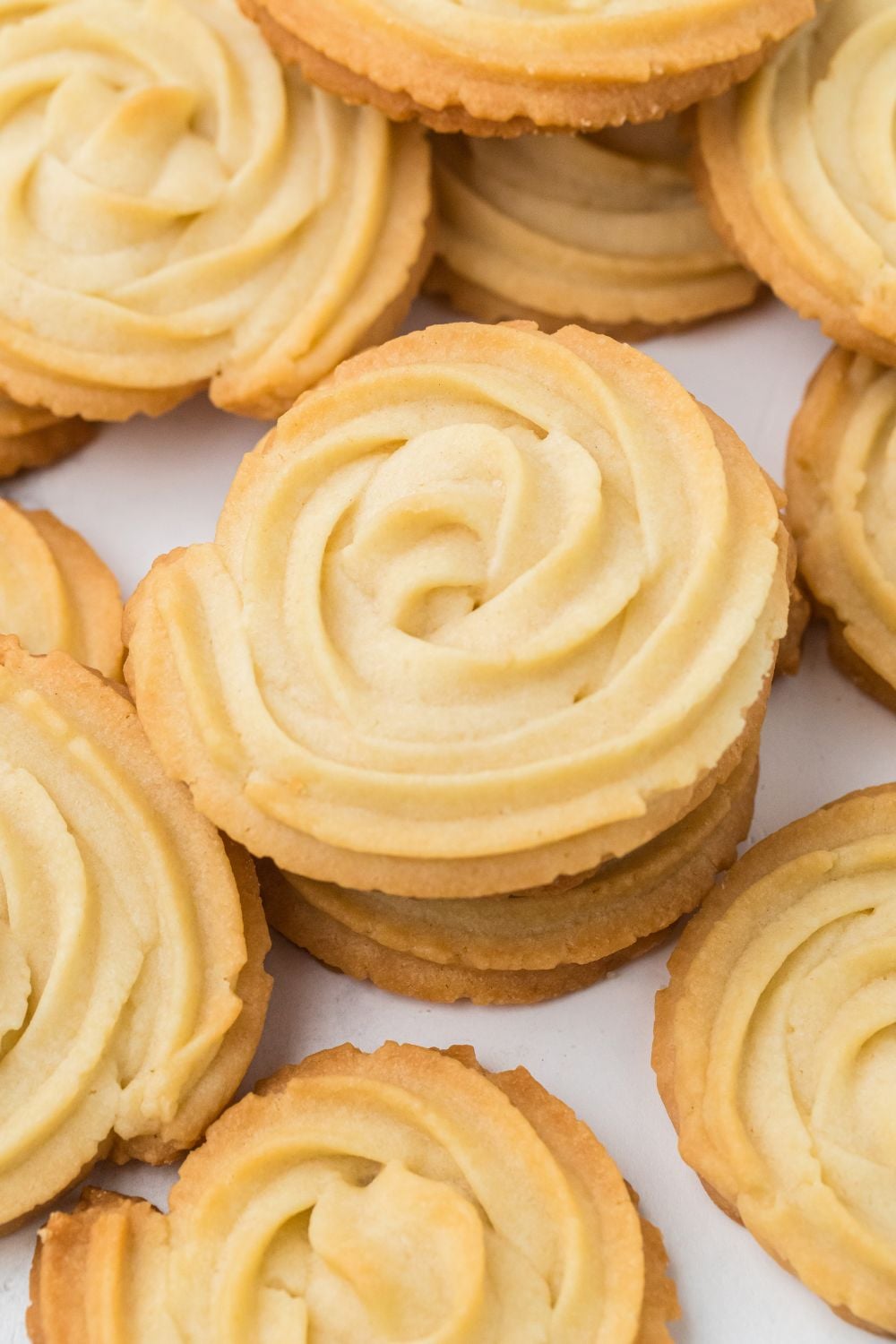 Butter Cookies stacked on table in stacks spread around 
