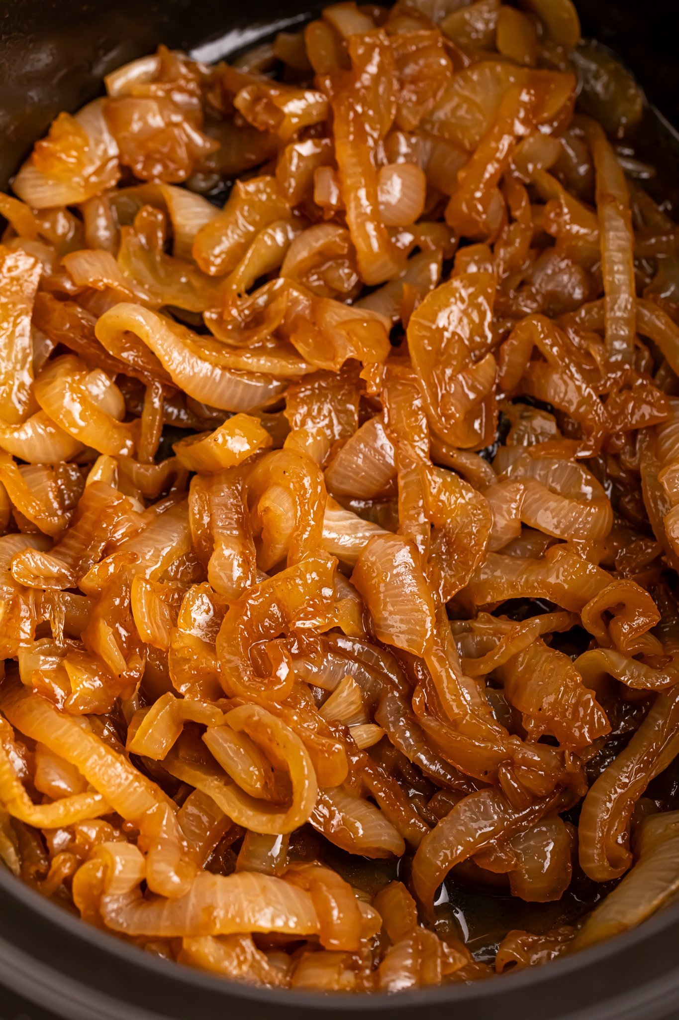 close of of the CrockPot Caramelized Onions in a black crockpot