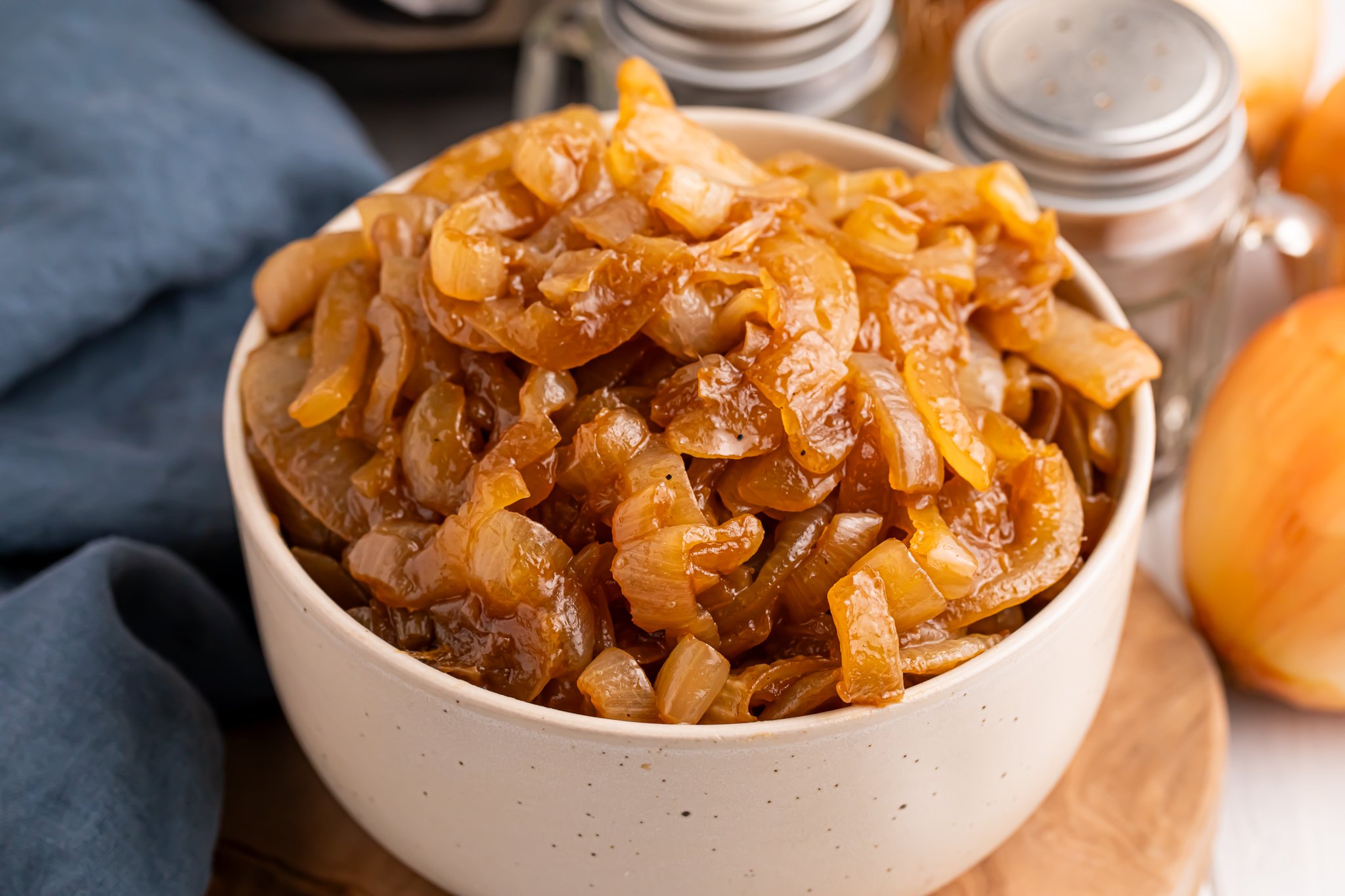 white bowl filled with CrockPot Caramelized Onions sitting on a table