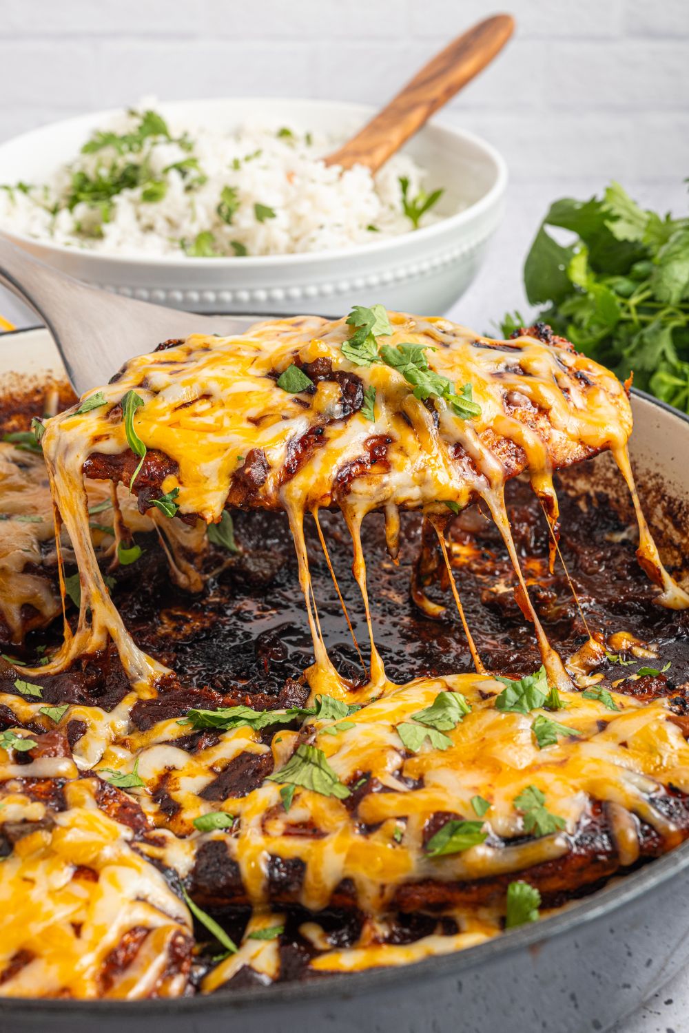Cheesy Salsa Chicken being lifted out of pan 