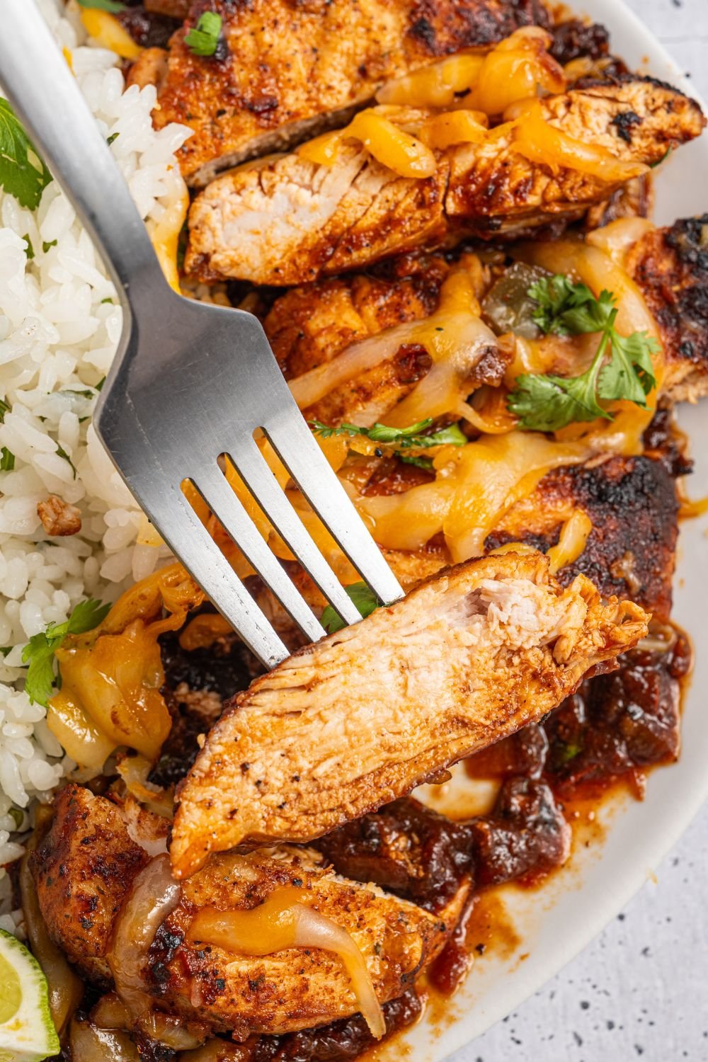 Cheesy Salsa Chicken on a fork and a bed of rice to the side 