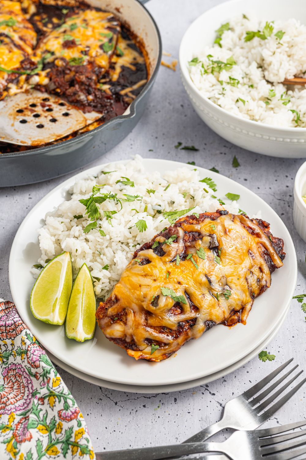 Cheesy Salsa Chicken on plate with a bed of rice to side and limes 
