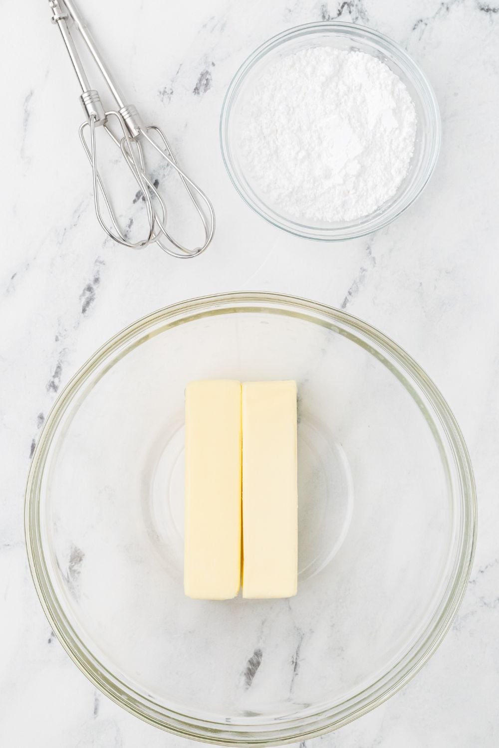 two sticks of butter in a bowl on table 