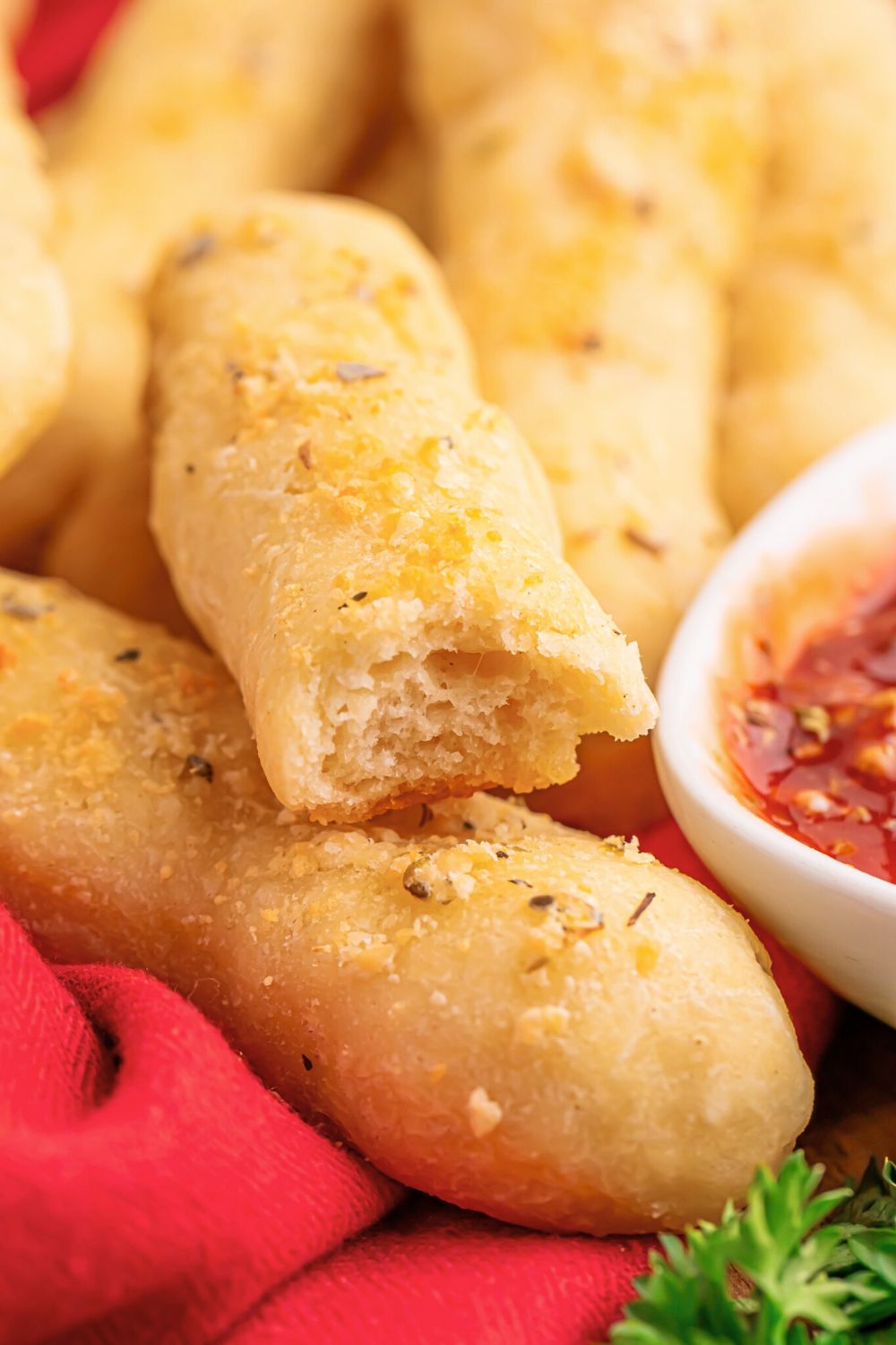 2 Ingredient Garlic Parmesan Breadsticks with a bite taken out of it with sauce to side 