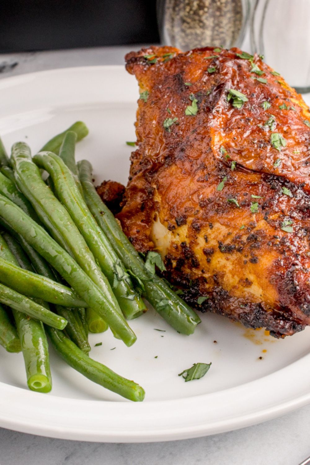 Air Fryer Chicken Breast on plate with green beans to side of plate 