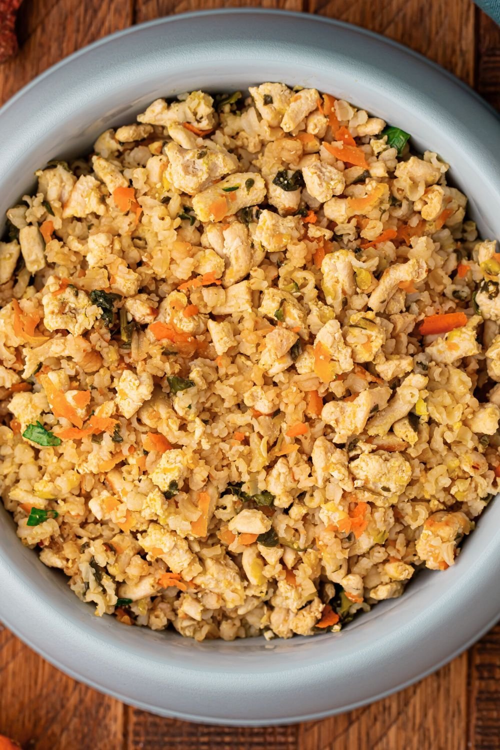 Homemade Turkey and Rice Dog Food with Veggies in a dog bowl on a wooden table 